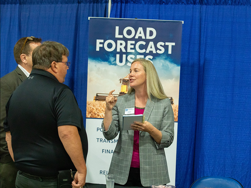 Employee talking at an Annual Meeting booth