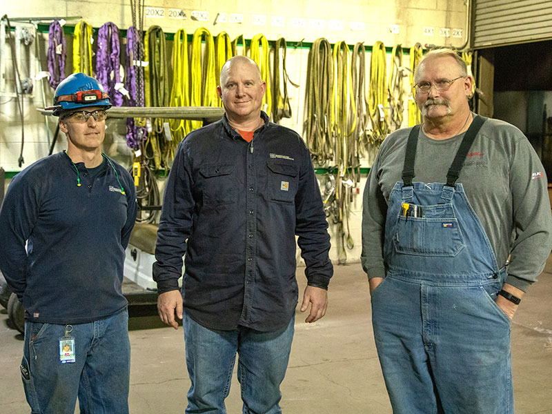 three men stand in shop