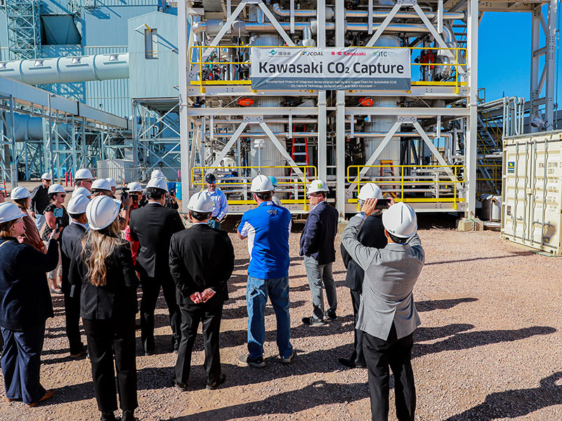 people in hard hats standing outside power plant