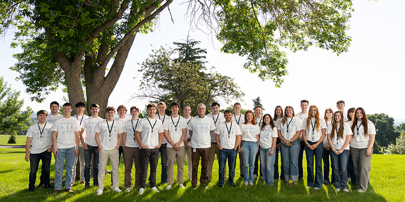 Interns stand outside in matching white shirts