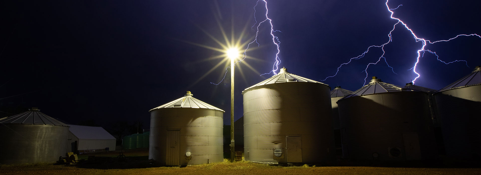 Lightning behind grain bins