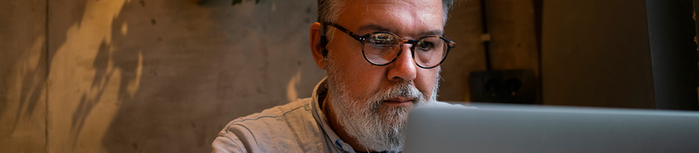 man wearing headphones while looking at a computer