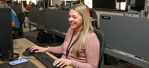 Woman in pink typing on keyboard