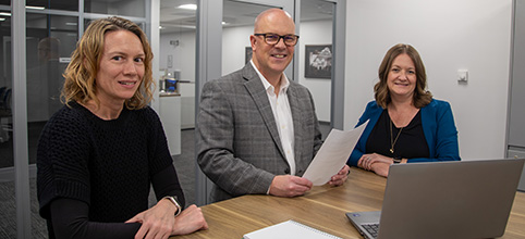 three people looking at laptop screen